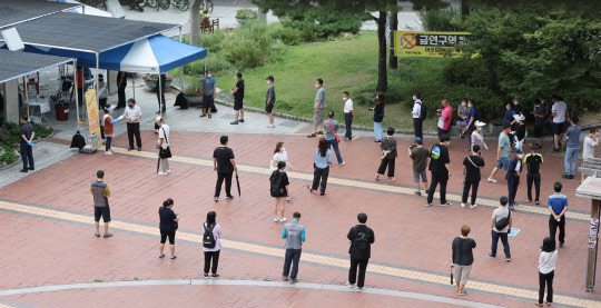23일 오전 서울 구로역 광장에 마련된 코로나19 임시 선별검사소를 찾은 시민들이 검사 순서를 기다리고 있다.   연합뉴스